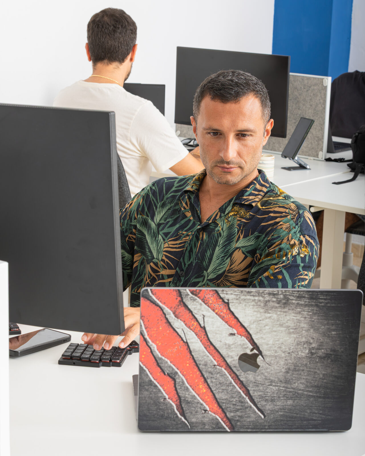 Two members working at adjacent desks in the FICO coworking space